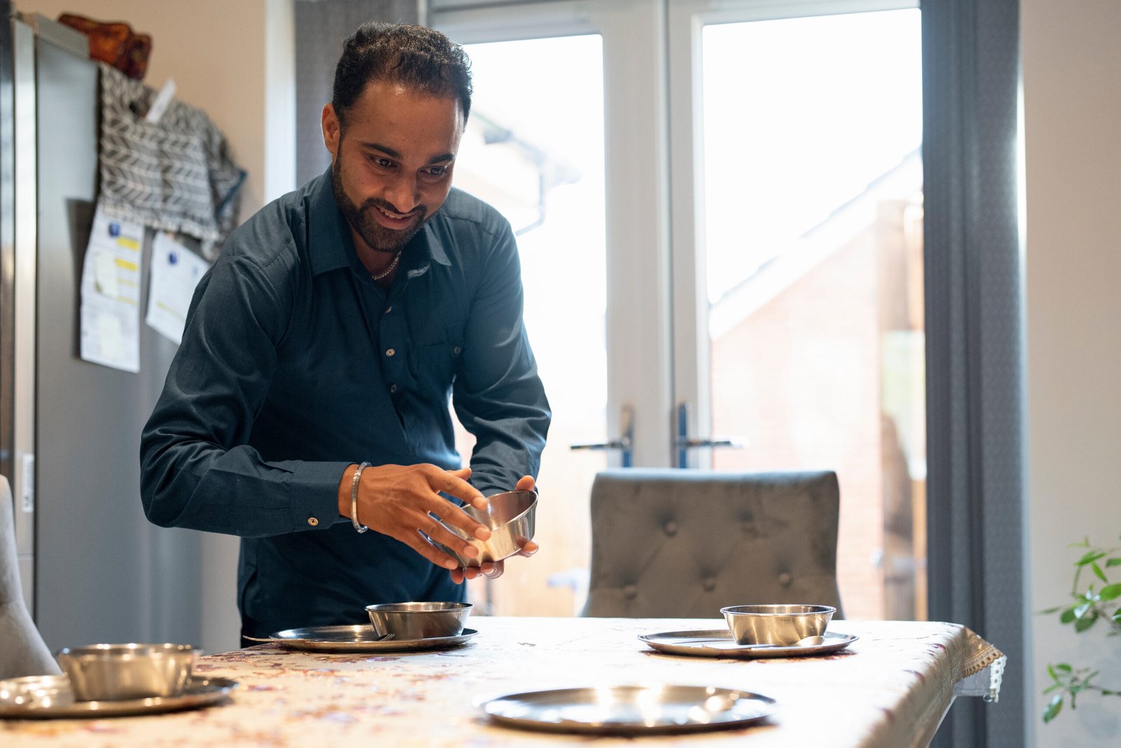 Smiling man setting table at home